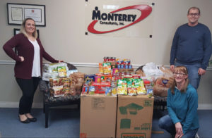Director of Medical Records Operations Abbey Williamson, Team Lead Casey Eagy, and Case Auditor Jennifer Gardner pose with all food donated by Monterey Consultants